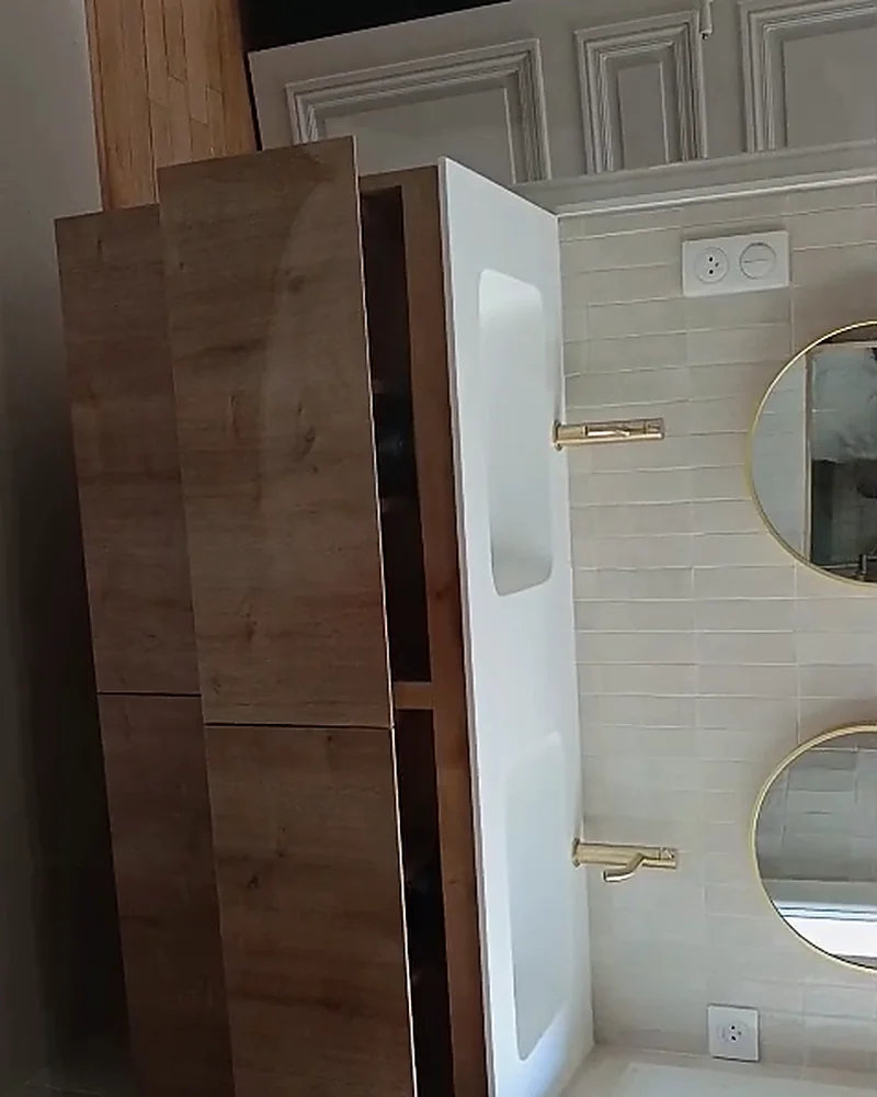 Salle de bain avec miroirs ovales et robinetterie dorée